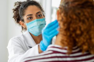 Doctor wearing surgical mask examining sf oral surgery sf oral surgery