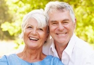 Older Couple Smiling in Front of a Tree