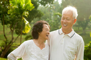 asian couple smiling in a field