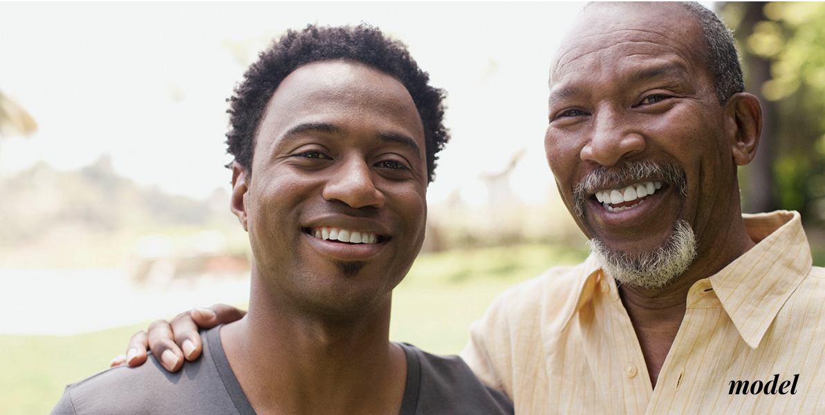 Smiling young man standing next to smiling father   sf oral surgery