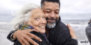 Smiling Older Couple Embracing At Beach